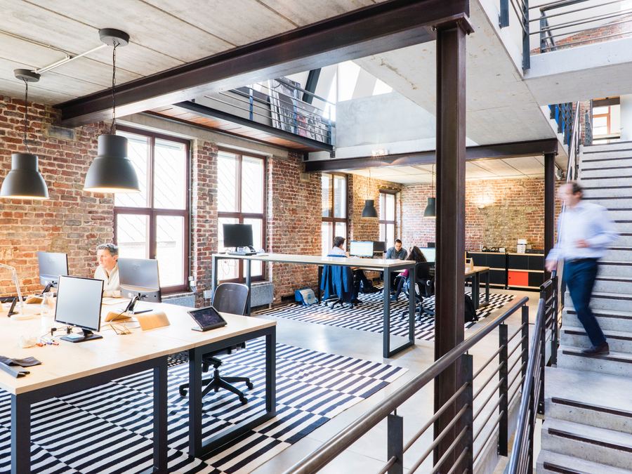 Renovated commercial office space with exposed brick and open workstations